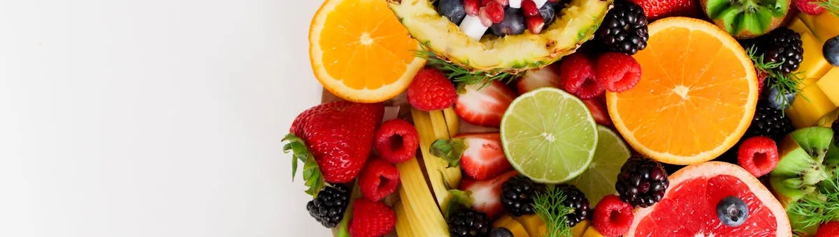 Dwarf lemon tree with ripe yellow lemons growing in a terracotta pot on a sunny patio