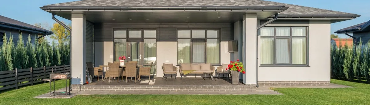Modern home with perfectly manicured lawn and outdoor living area — the result of wire-free robot mowing